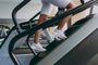 A woman is using an escalator in a gym.