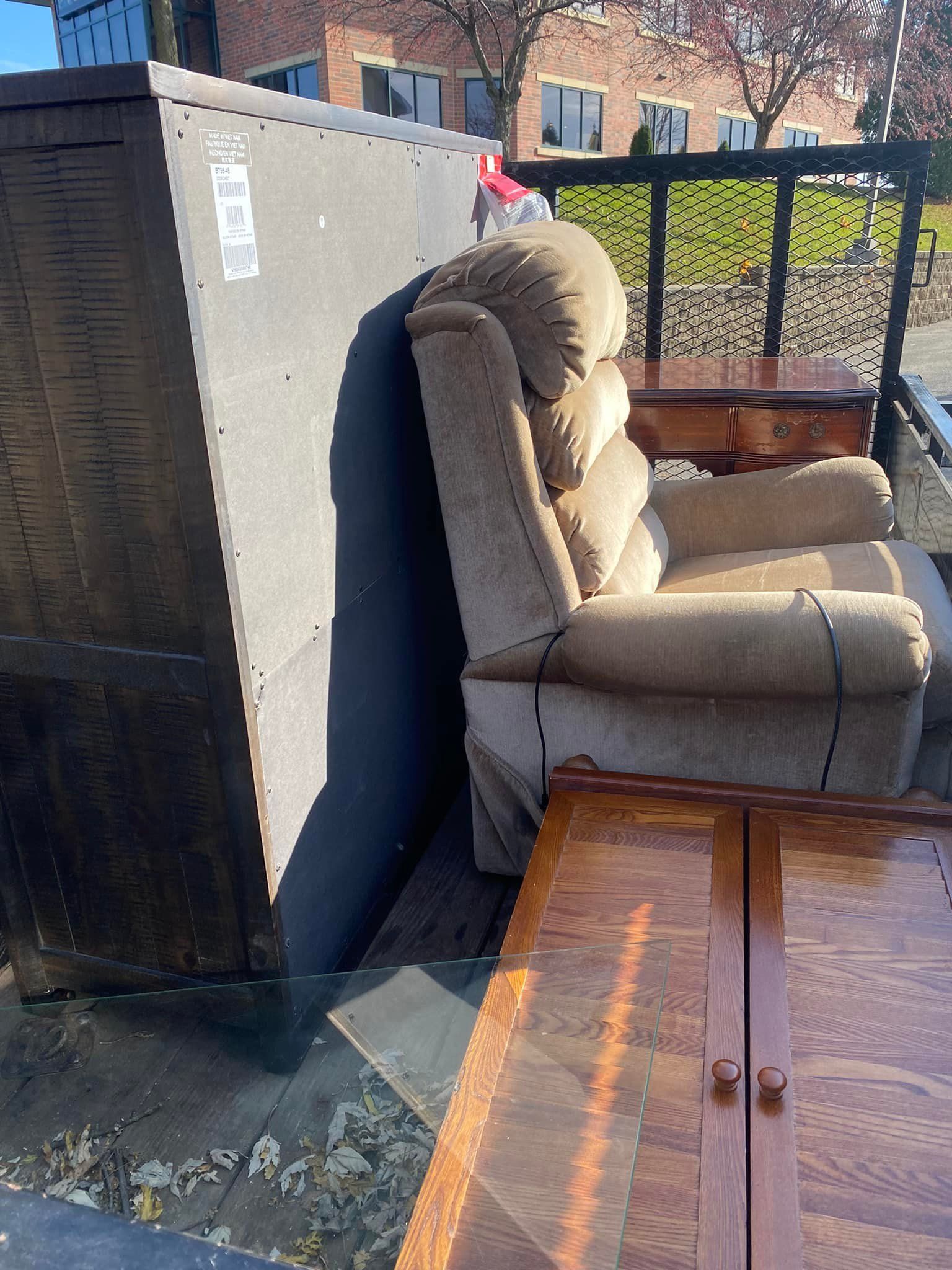A recliner is sitting on top of a wooden table next to a dresser.