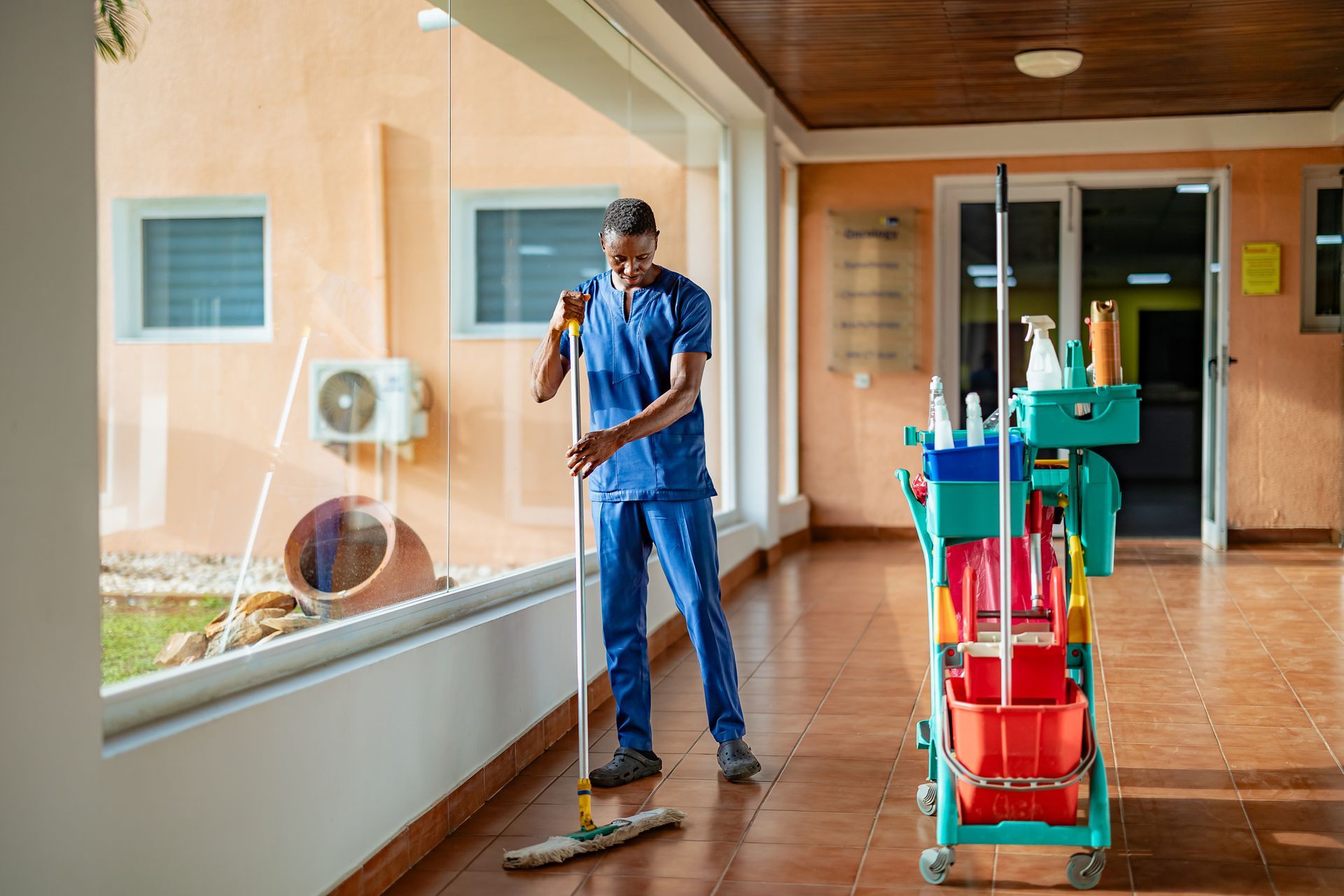 Male porter cleaning floor at an office building. Male porter cleaning floor at an office building.
