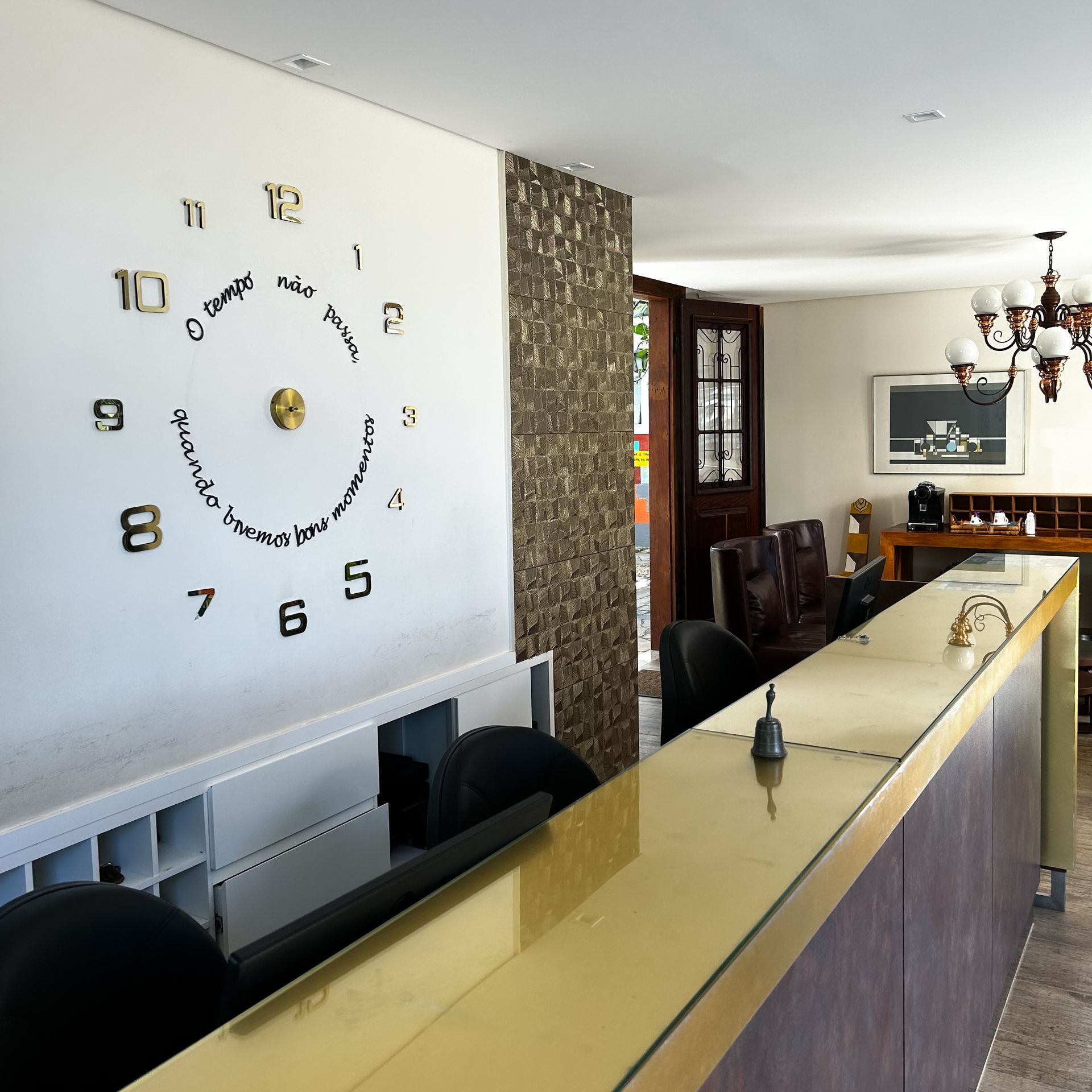 Um grande relógio na parede marca as horas como 10:10