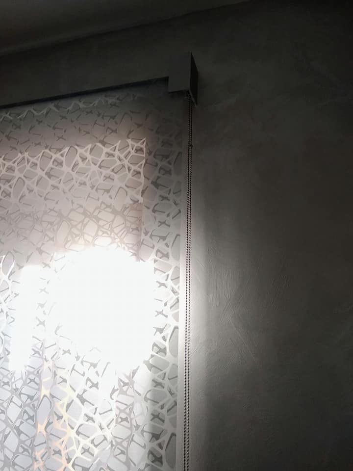 Pannello decorativo in vetro satinato con una luce brillante che filtra attraverso, da posizionare accanto a una parete scura o a un telaio di una porta.