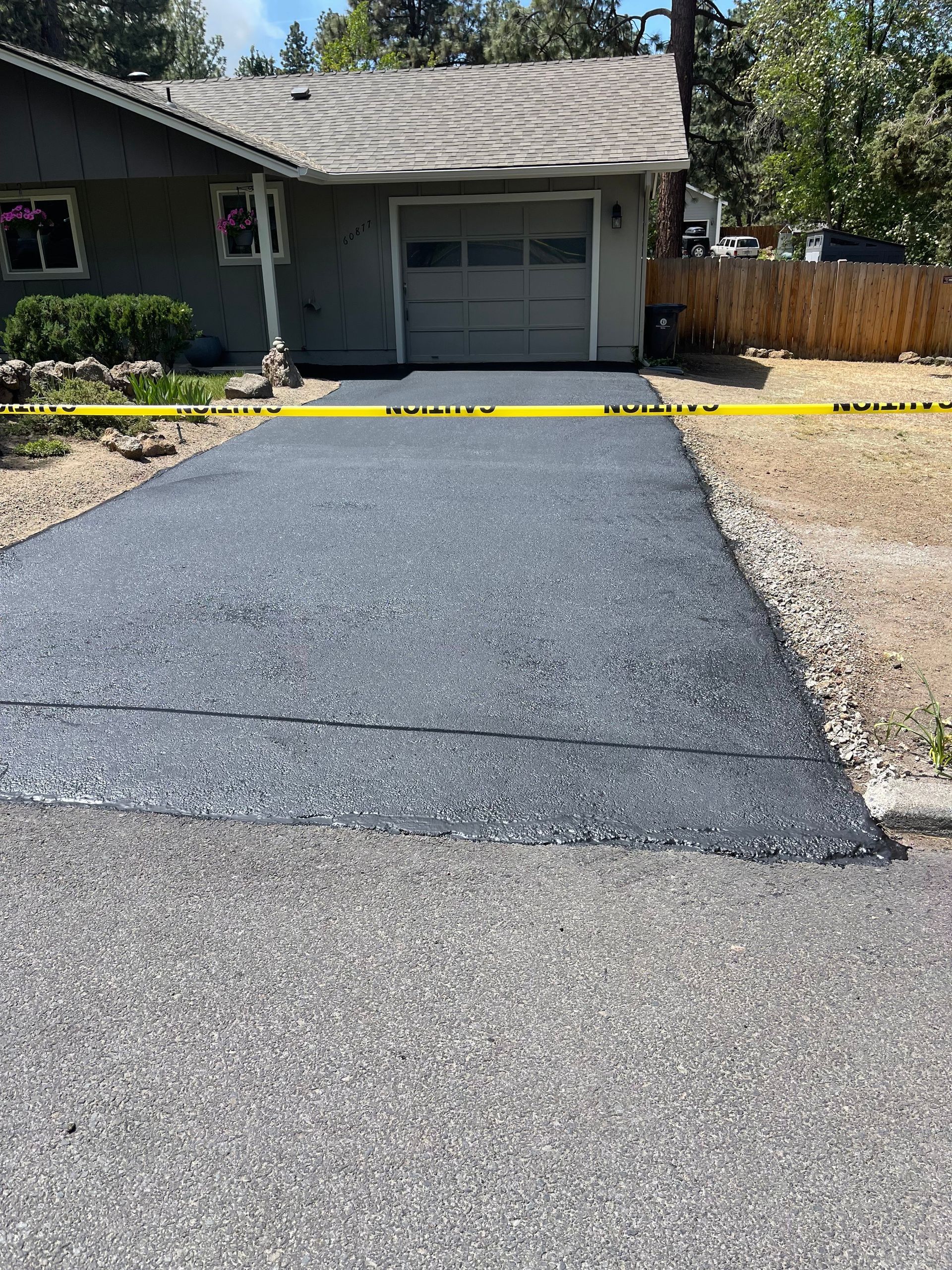 A driveway is being paved in front of a house.