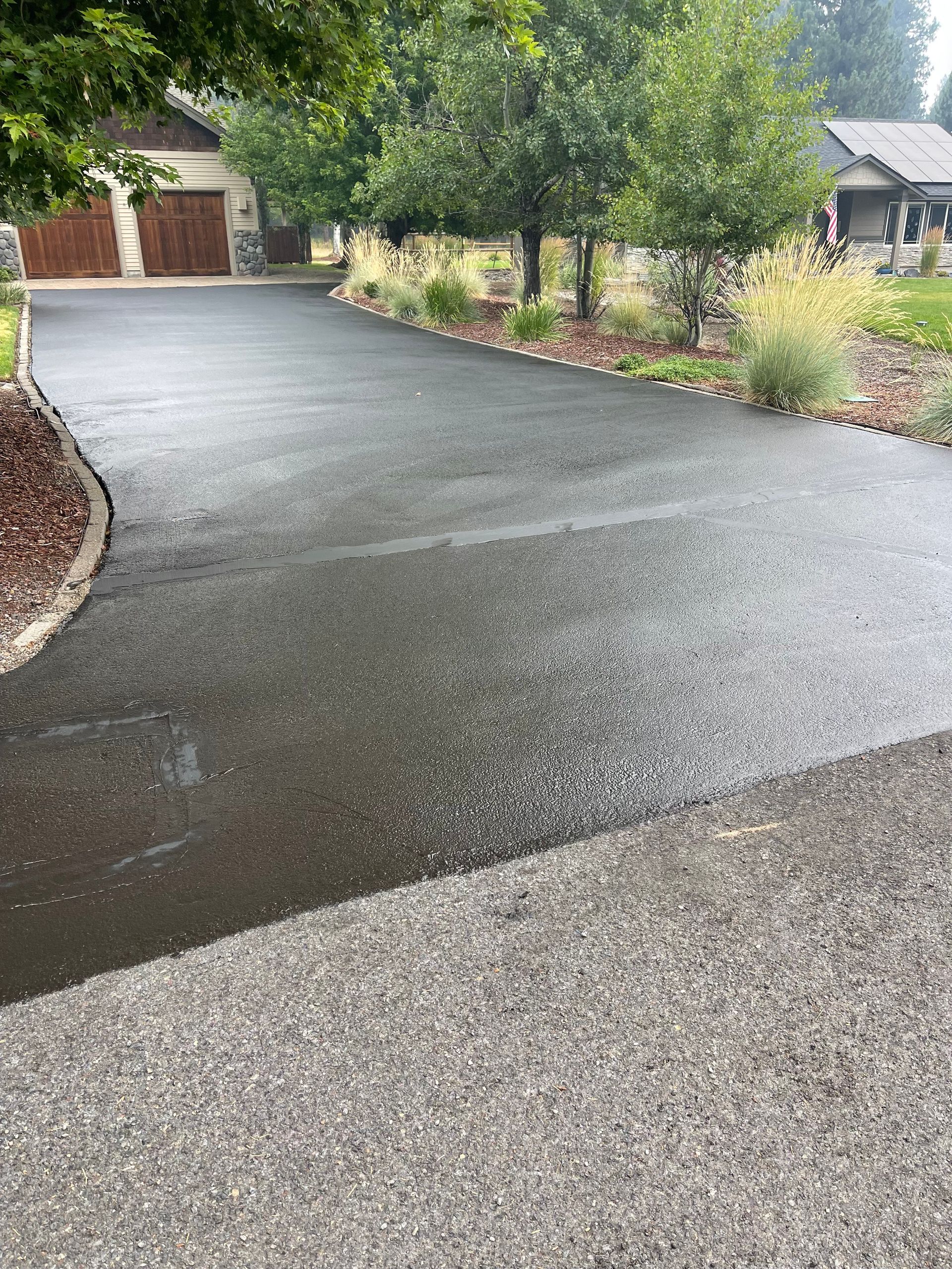 A driveway leading to a house with trees on the side of it.