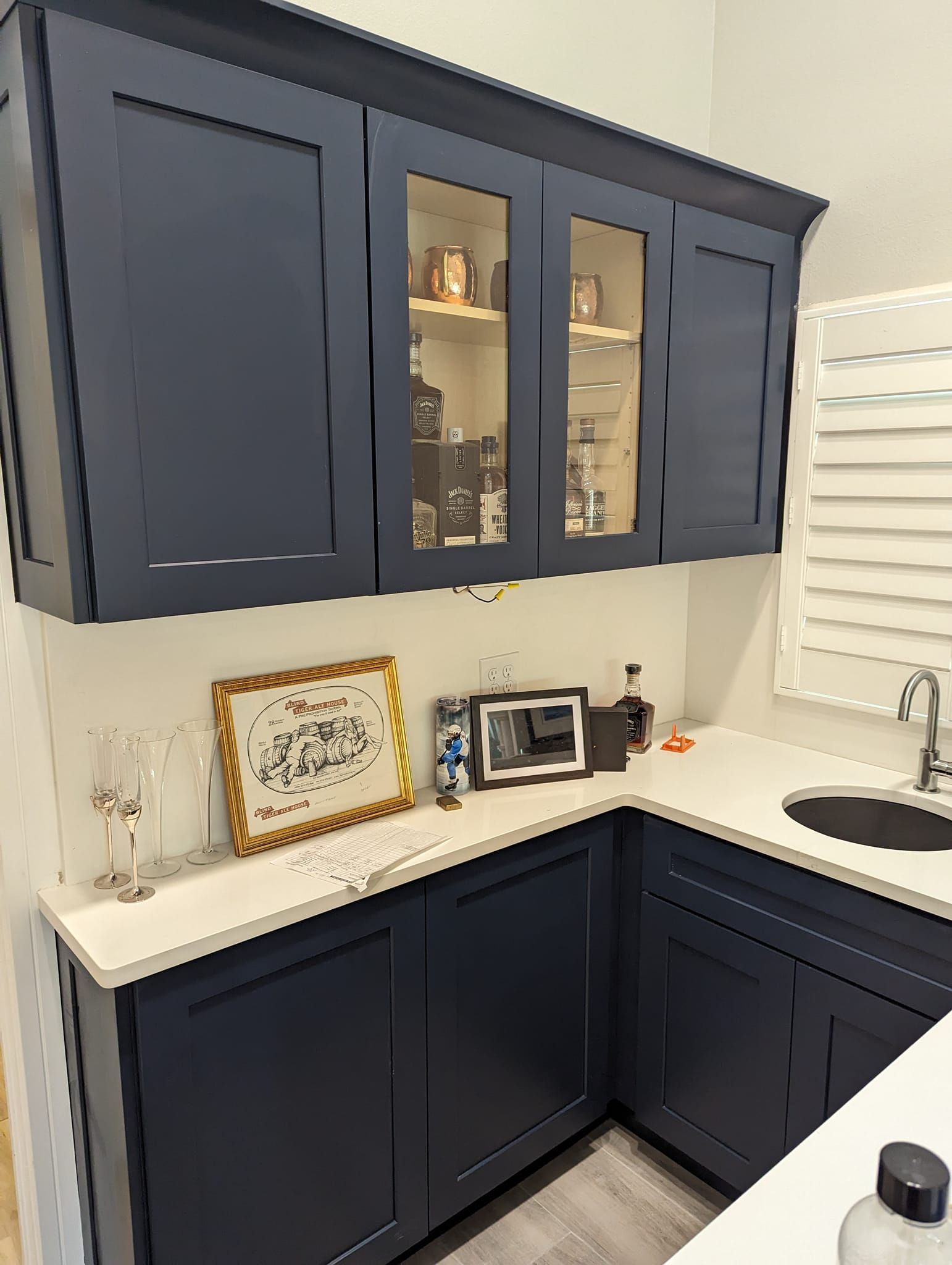 Dark blue cabinets with a white countertop and a framed picture.