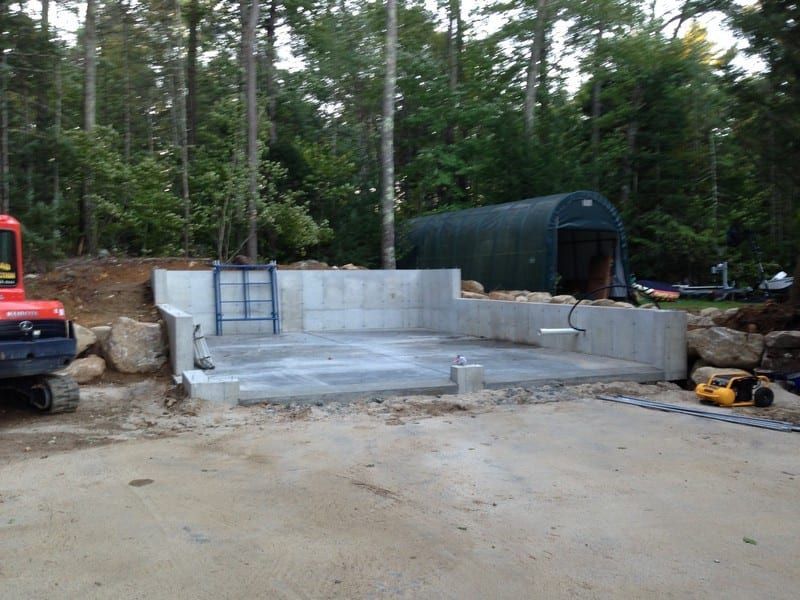 A large concrete structure is being built in the middle of a forest.
