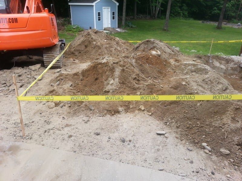 A large pile of dirt is surrounded by caution tape