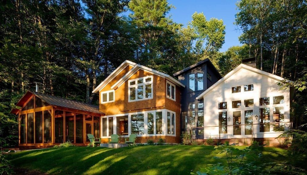 A large house with a lot of windows is surrounded by trees.