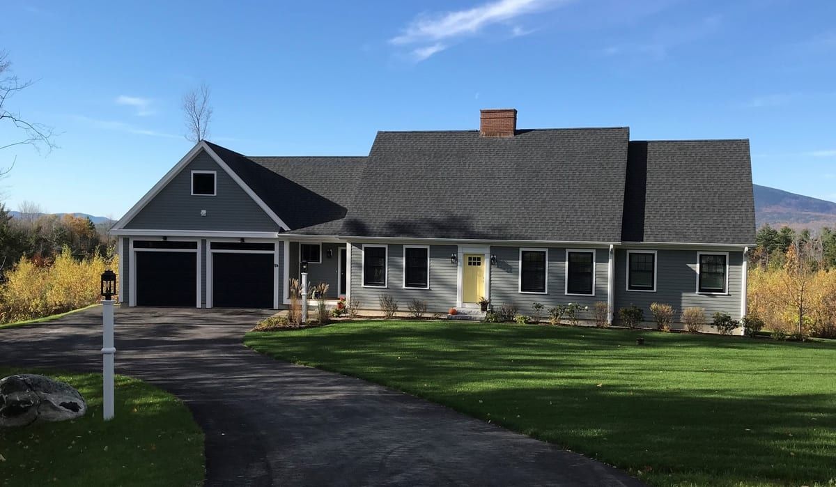 A large house with a garage and a driveway in front of it.