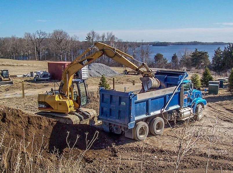 An excavator is loading dirt into a dump truck
