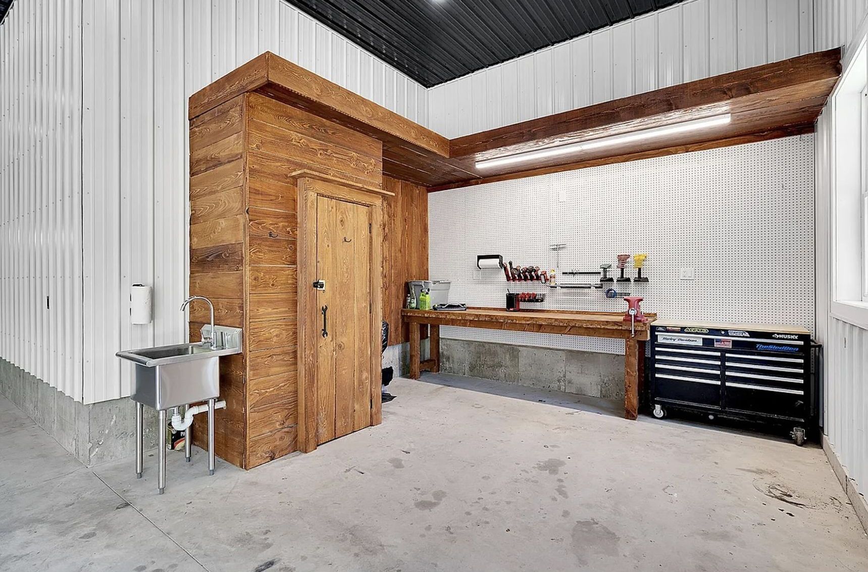A garage with a sink , table , and tools.