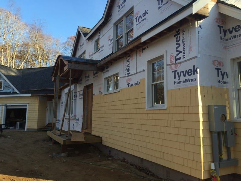 A house is being built with yellow siding and styrofoam.