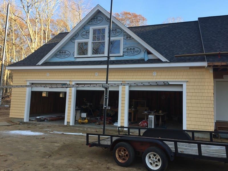 A man is standing on a ladder in front of a house