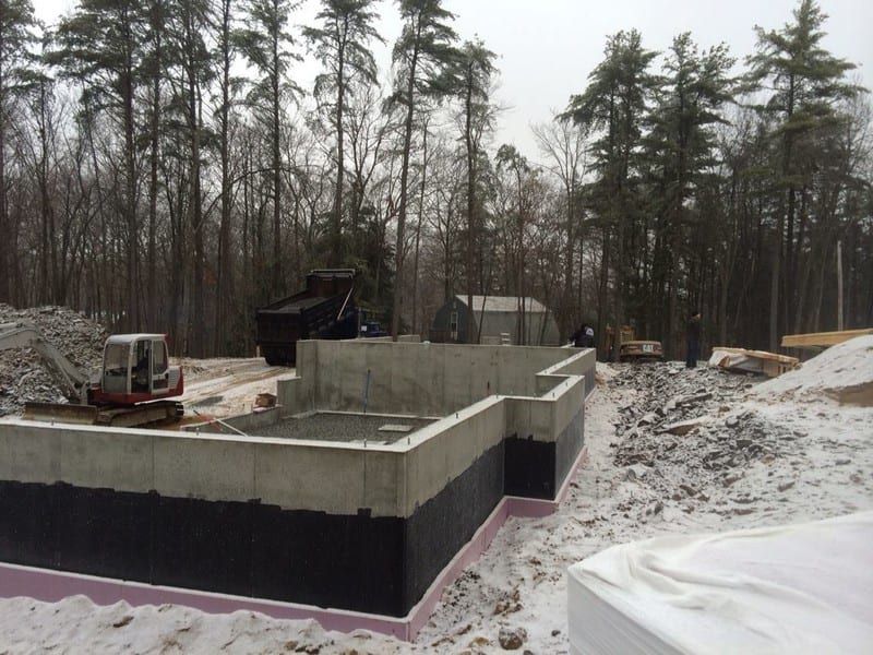 A construction site in the snow with trees in the background