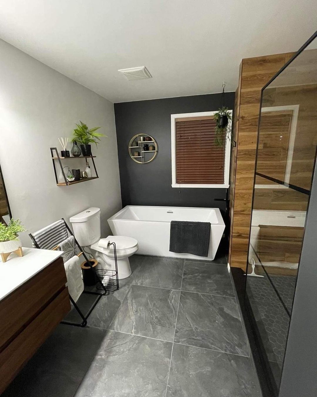 Une salle de bain avec baignoire, WC, lavabo et miroir.