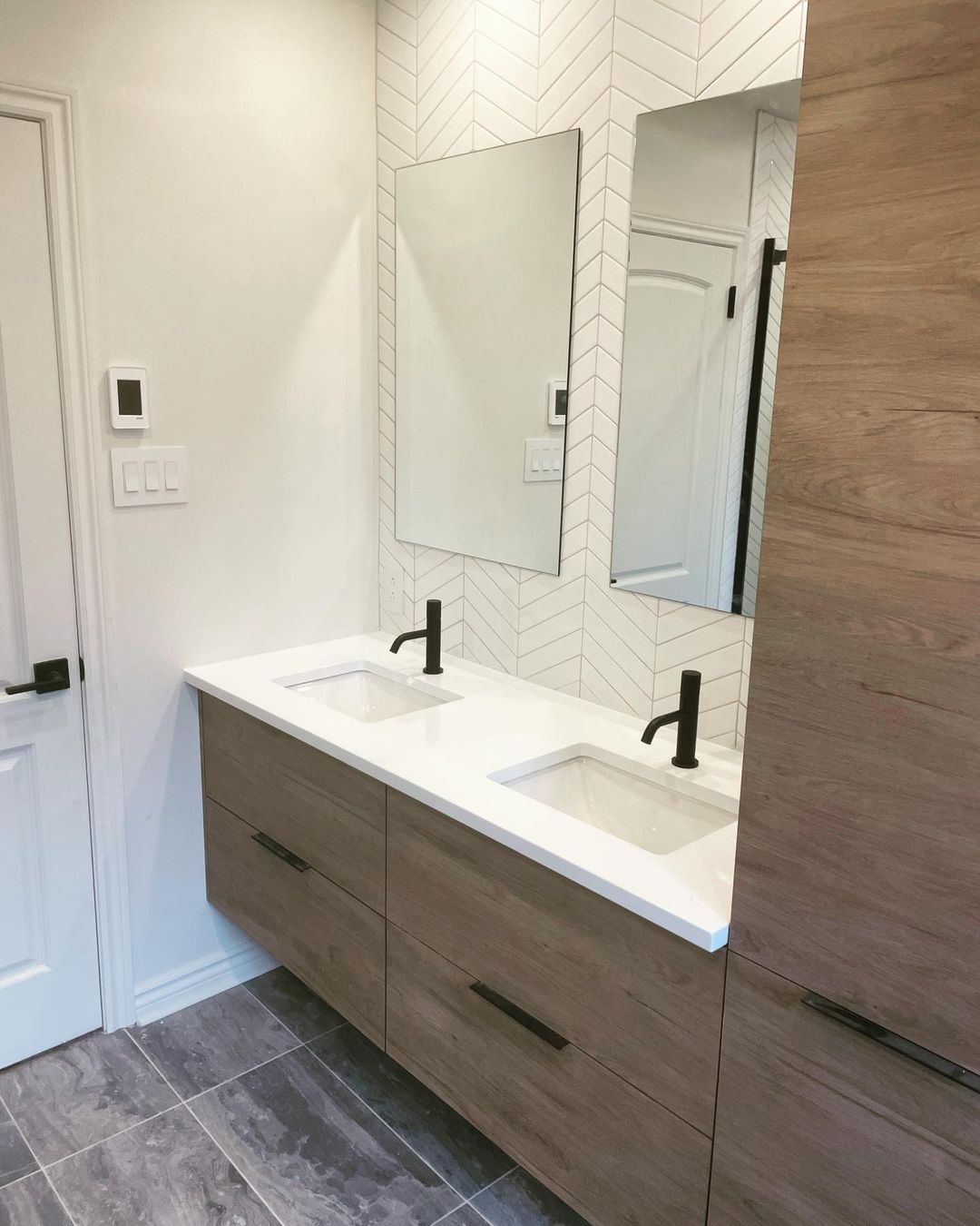 Une salle de bain avec deux lavabos et un miroir.
