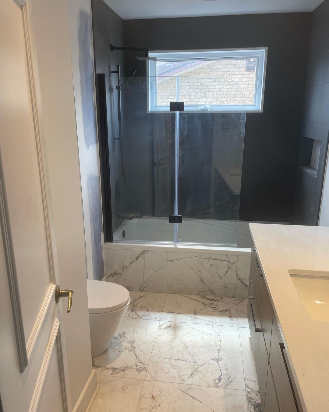 Une salle de bain avec WC, lavabo, baignoire et douche.