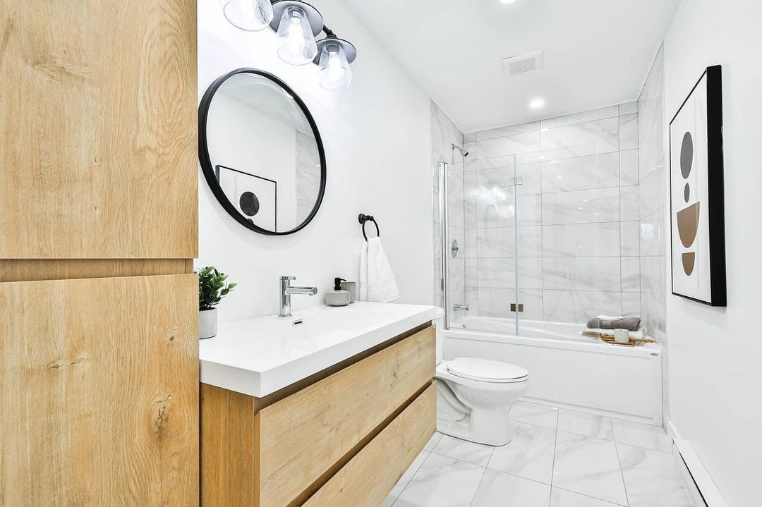 Une salle de bain avec lavabo, toilettes et miroir.
