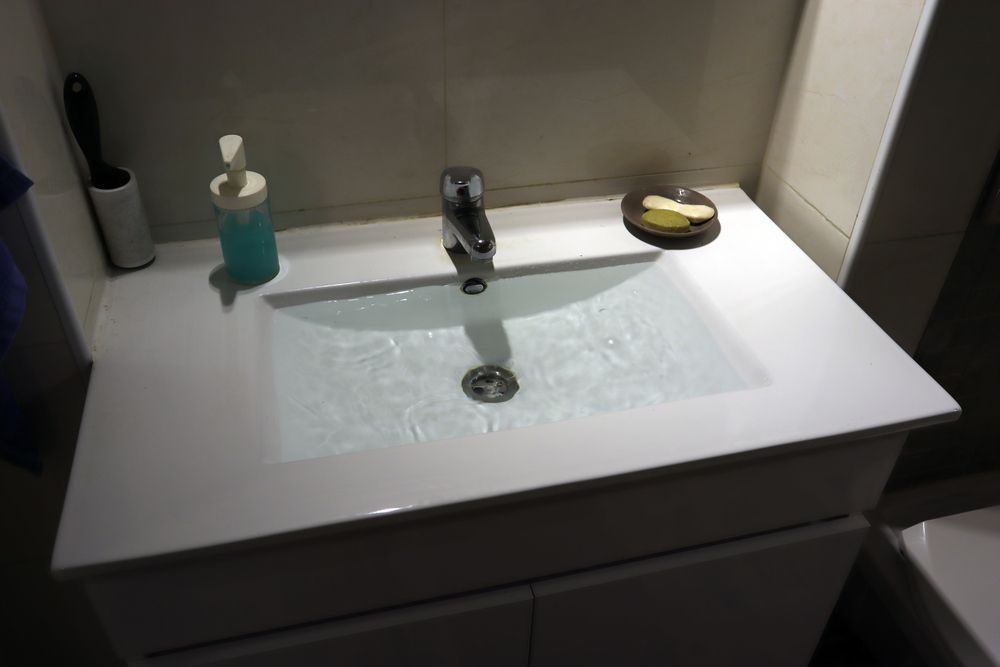 Un lavabo de salle de bain avec un distributeur de savon et un porte-savon