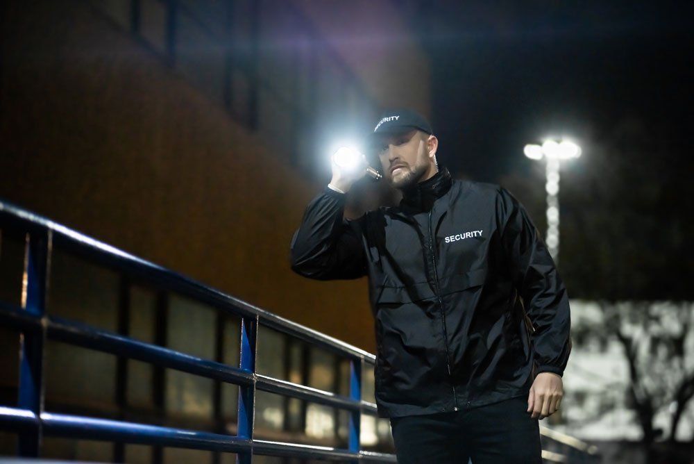 Security guard performing nighttime rounds in parking lot