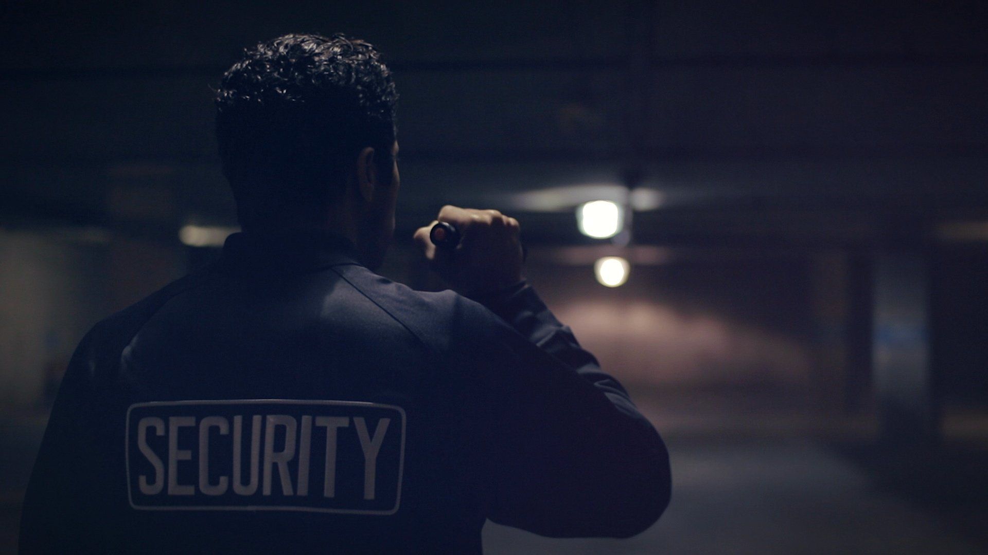 Nighttime security officer inspecting alleyway in downtown San Diego