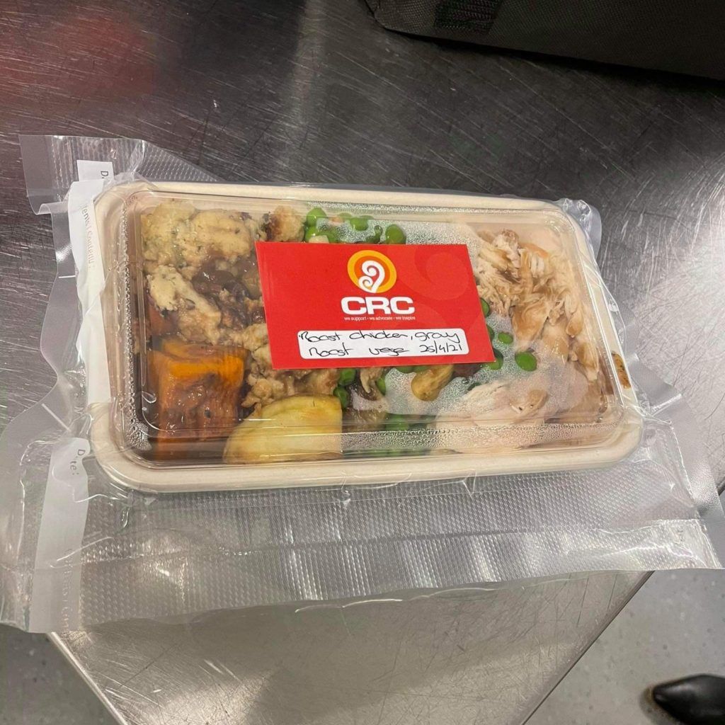 A plastic container of food with a red sticker that says crc on it.