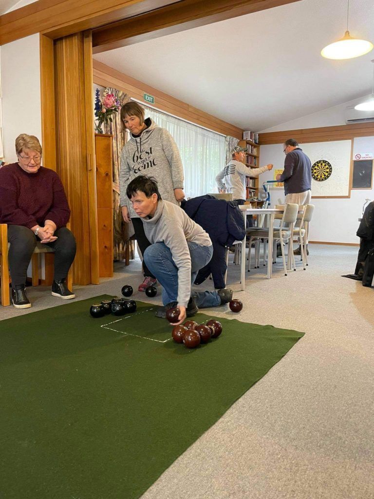 A group of people are playing bowling in a room.