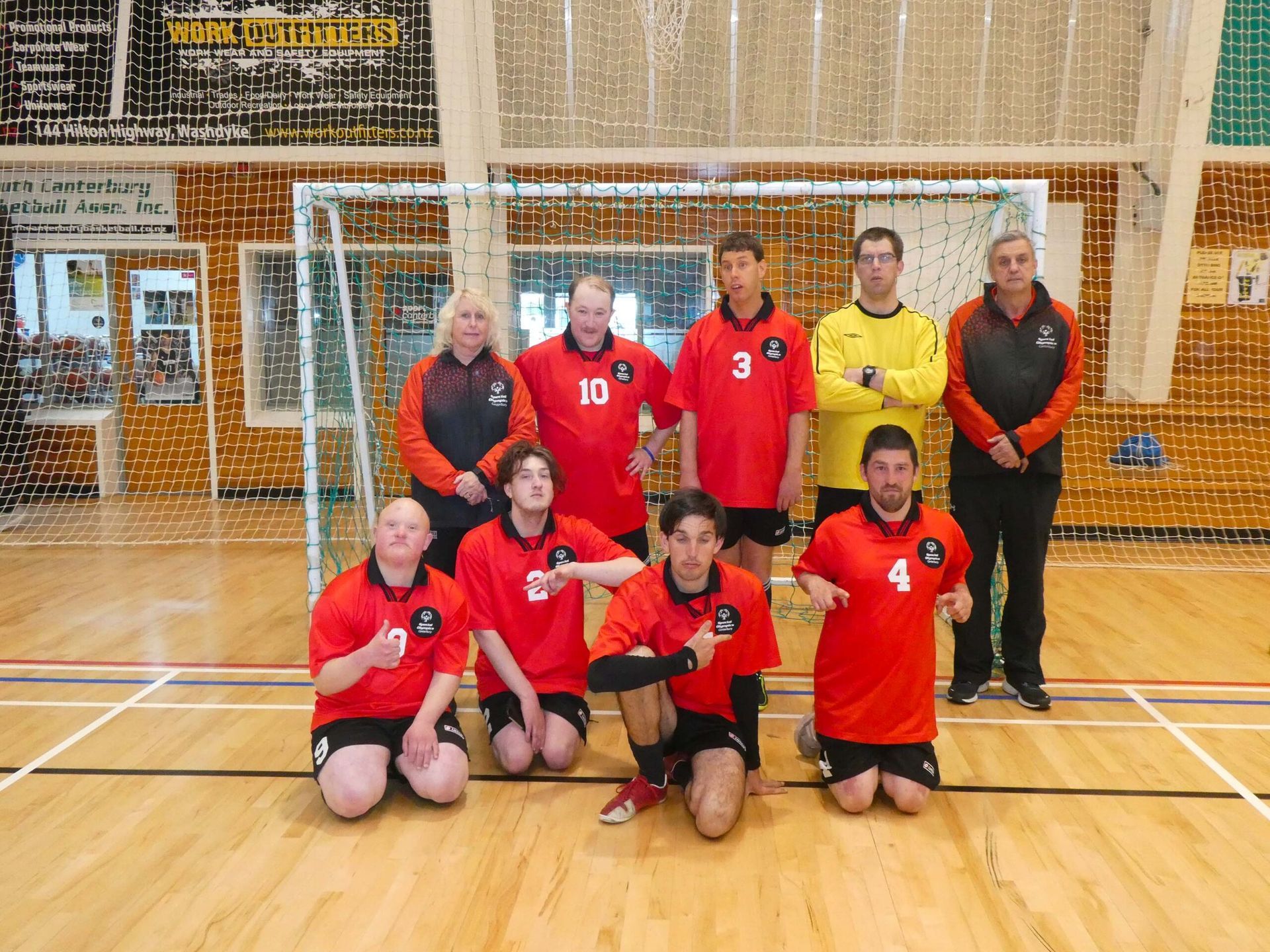 A group of people posing for a picture in front of a soccer goal