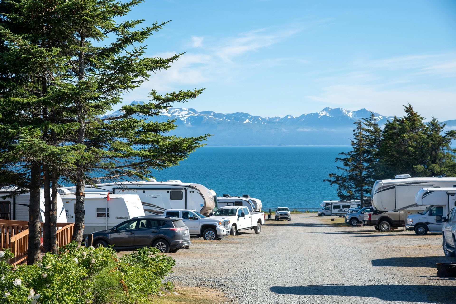RV campground by a blue lake with mountains in the distance
