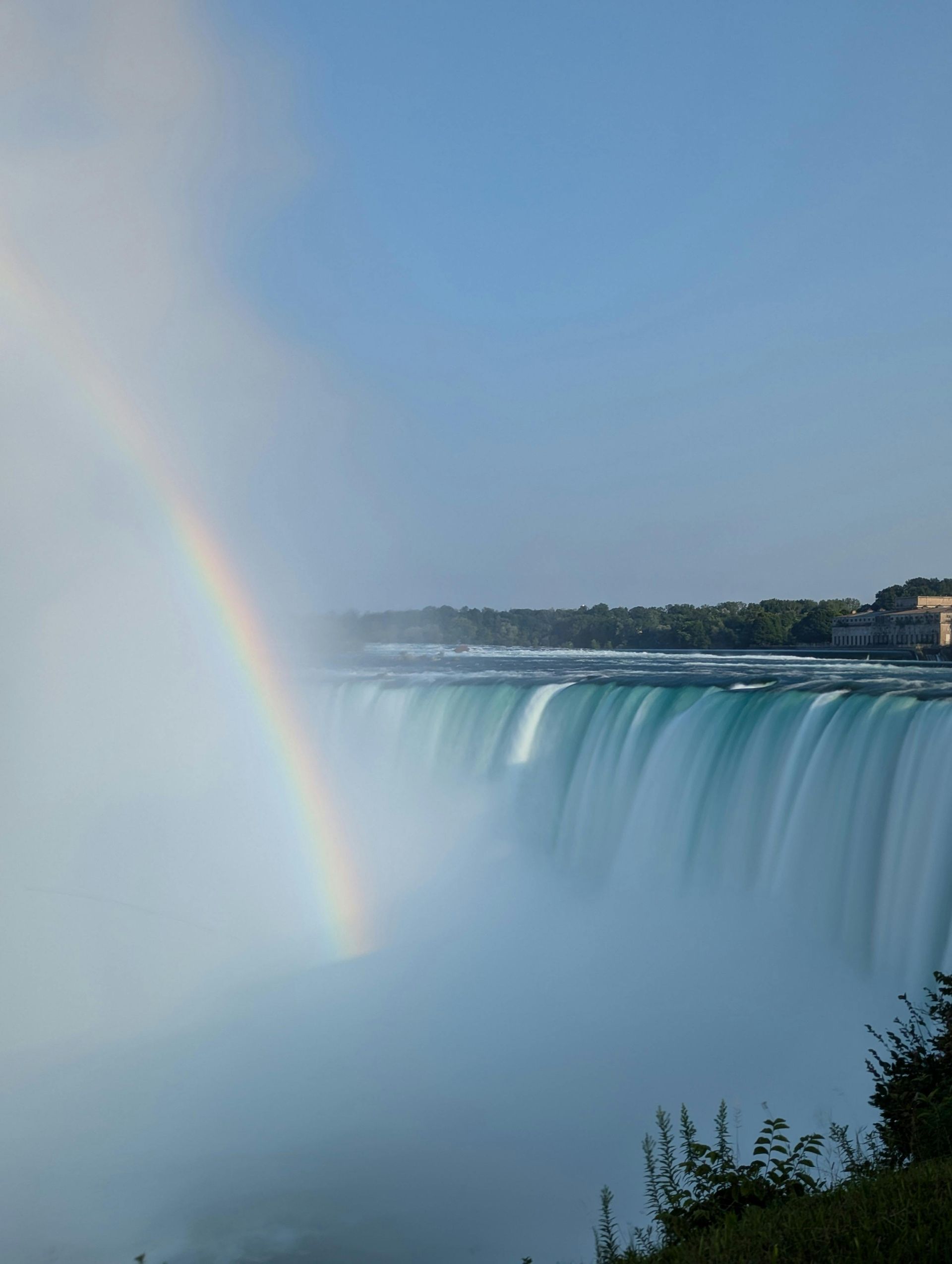 Rainbow over Niagara Falls with mist rising from the waterfall edge