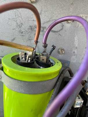 Close-up of a green capacitor with purple and brown wires connected on top.