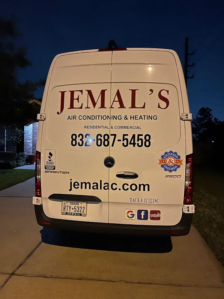 White Jemal’s HVAC service van parked at night with phone number and website on the back.