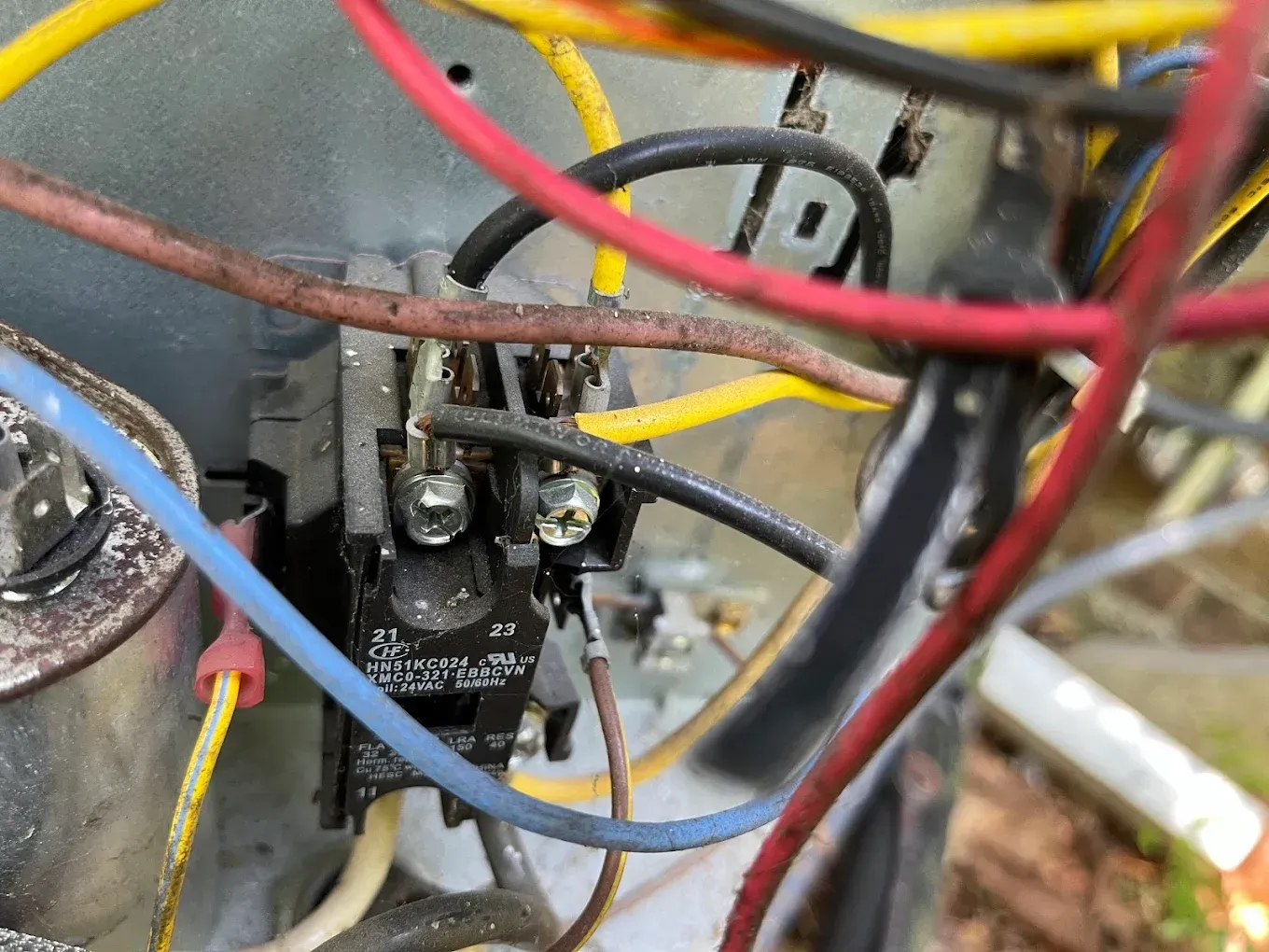 Close-up of electrical wiring and components inside a device, with red, yellow, blue, and black wires.