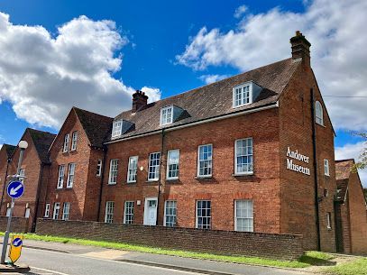 Brick apartment building on a street corner under a blue sky with clouds