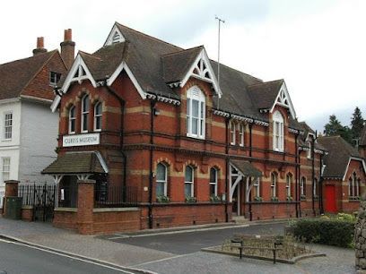 Red brick Victorian-style house with white trim and gabled roof on a street corner