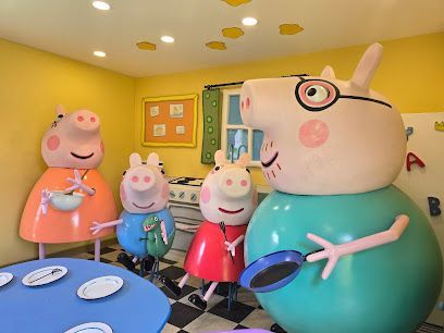 Peppa Pig family figurines in a bright toy room, with Daddy Pig holding a frying pan.