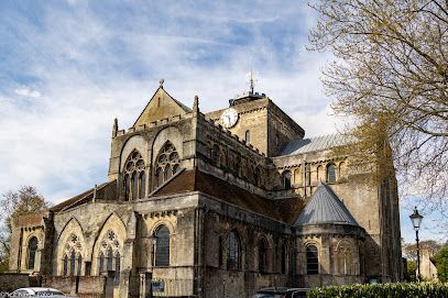 Stone cathedral with Gothic arches and towers under a blue sky, seen from the side