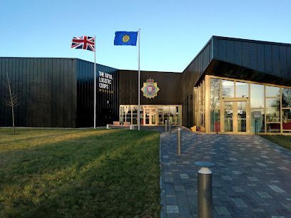 Modern dark-clad building with UK and Kazakh flags at the entrance at dusk