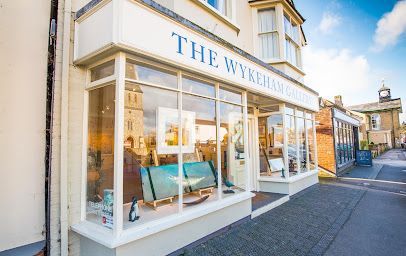 Shopfront with large windows and sign reading “THE W…” on a sunny street