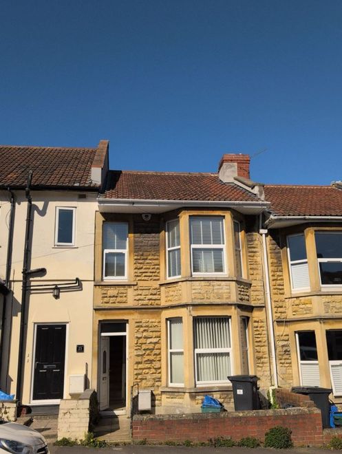 Row of terraced houses with a yellow brick facade under a clear blue sky