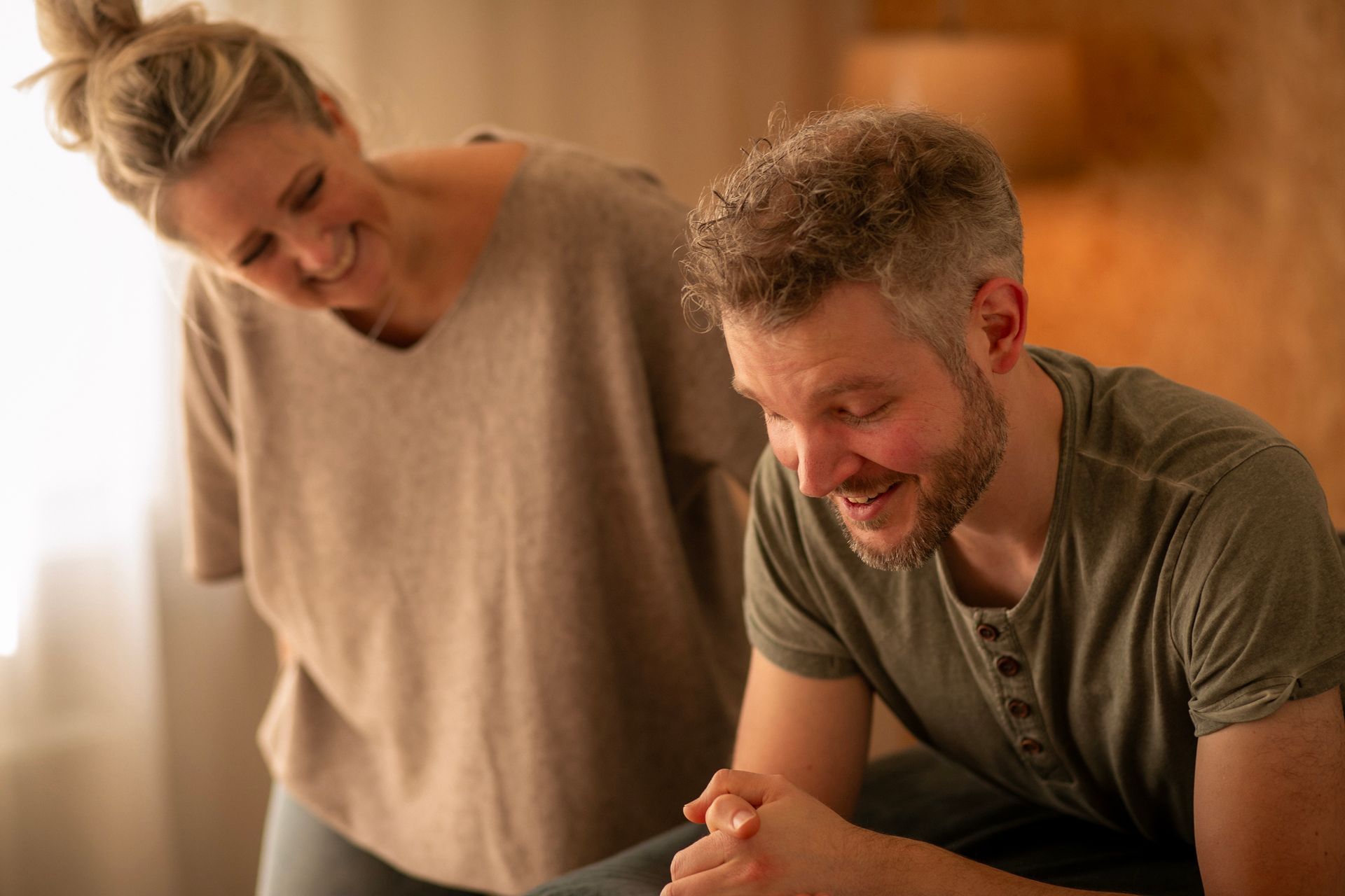 Twee mensen glimlachen na een mooie sessie, in overdekte ruimte.