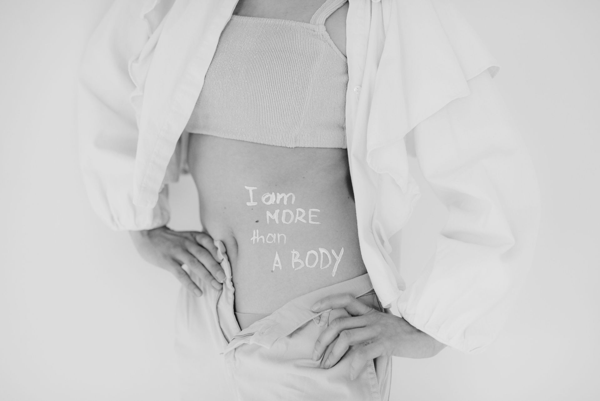 Zwart-witfoto van een buik met tekst ‘I am more than a body’, als verwijzing naar lichaamssignalen.