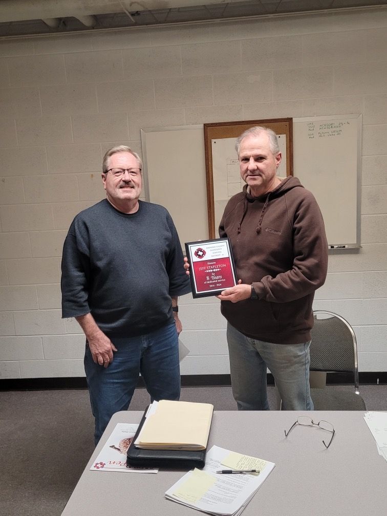 Two men are standing next to each other holding a certificate.