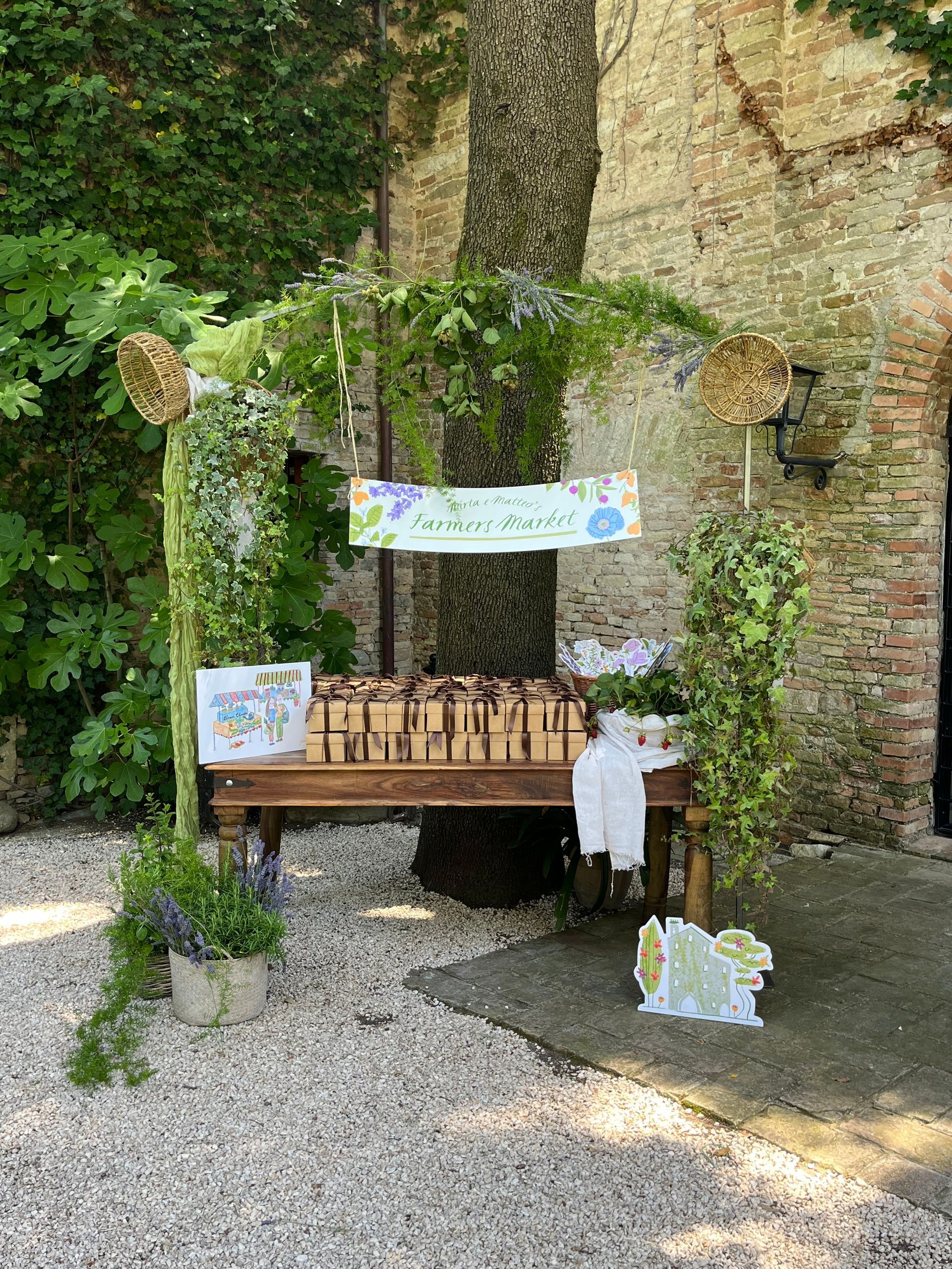 Woodland memorial bench with banners and potted plants against a stone wall in a garden.