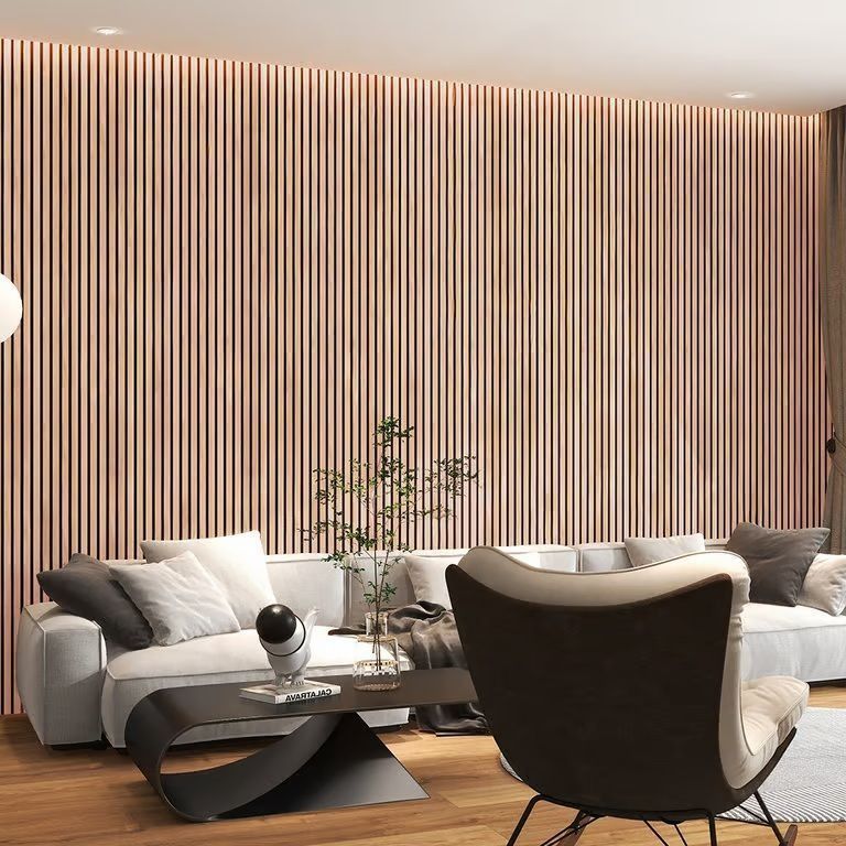 Rincón de comedor moderno con pared a rayas, mesa pequeña y dos sillas de mimbre sobre una alfombra gris.