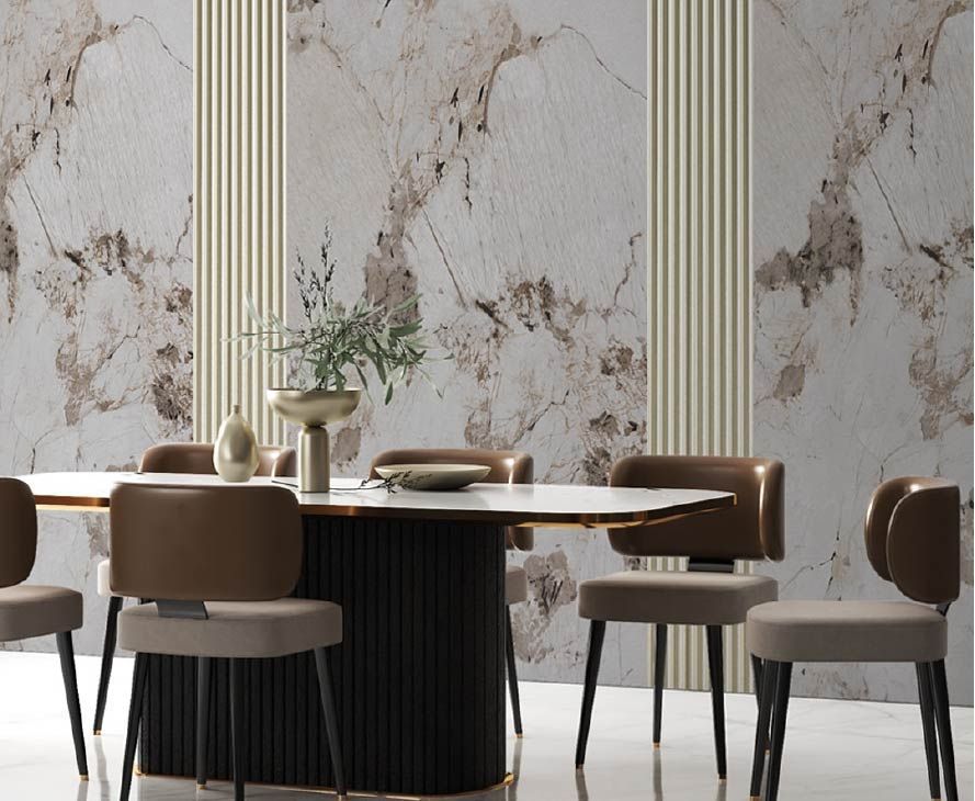 Comedor moderno con pared con estampado de mármol, sillas marrones y una mesa ovalada oscura con un jarrón como centro de mesa.