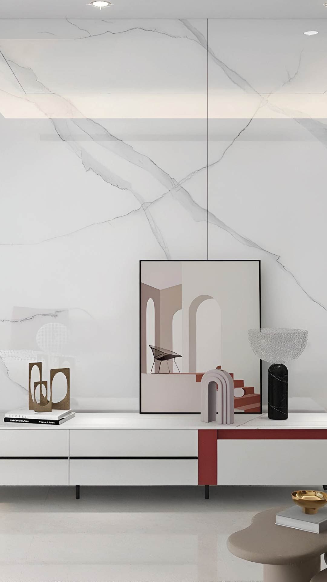 Sala de estar moderna y minimalista con pared de mármol blanco, mesa con detalles en rojo, espejo y jarrones decorativos.