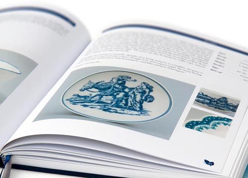 a copy of the caughley blue and white patterns book is open to a page with a picture of a plate on it .