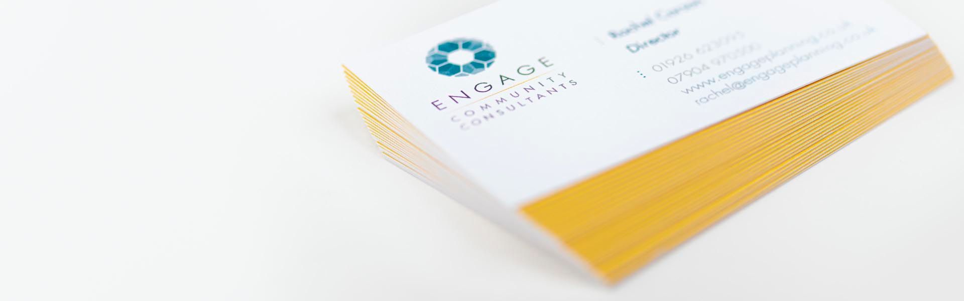 a stack of business cards for engage community consultants