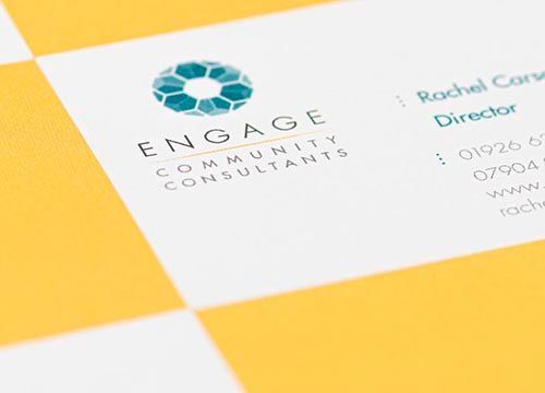 a close up of a business card for engage community consultants on a yellow and white checkered background .