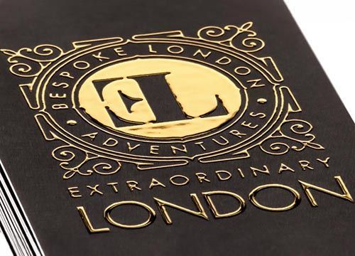 a close up of a business card with a gold logo on it.